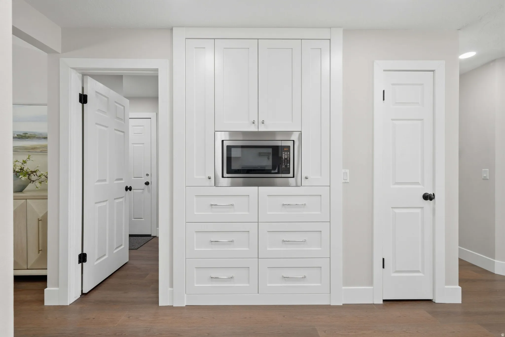 Built-in white cabinetry featuring a stainless steel microwave and ample drawer storage