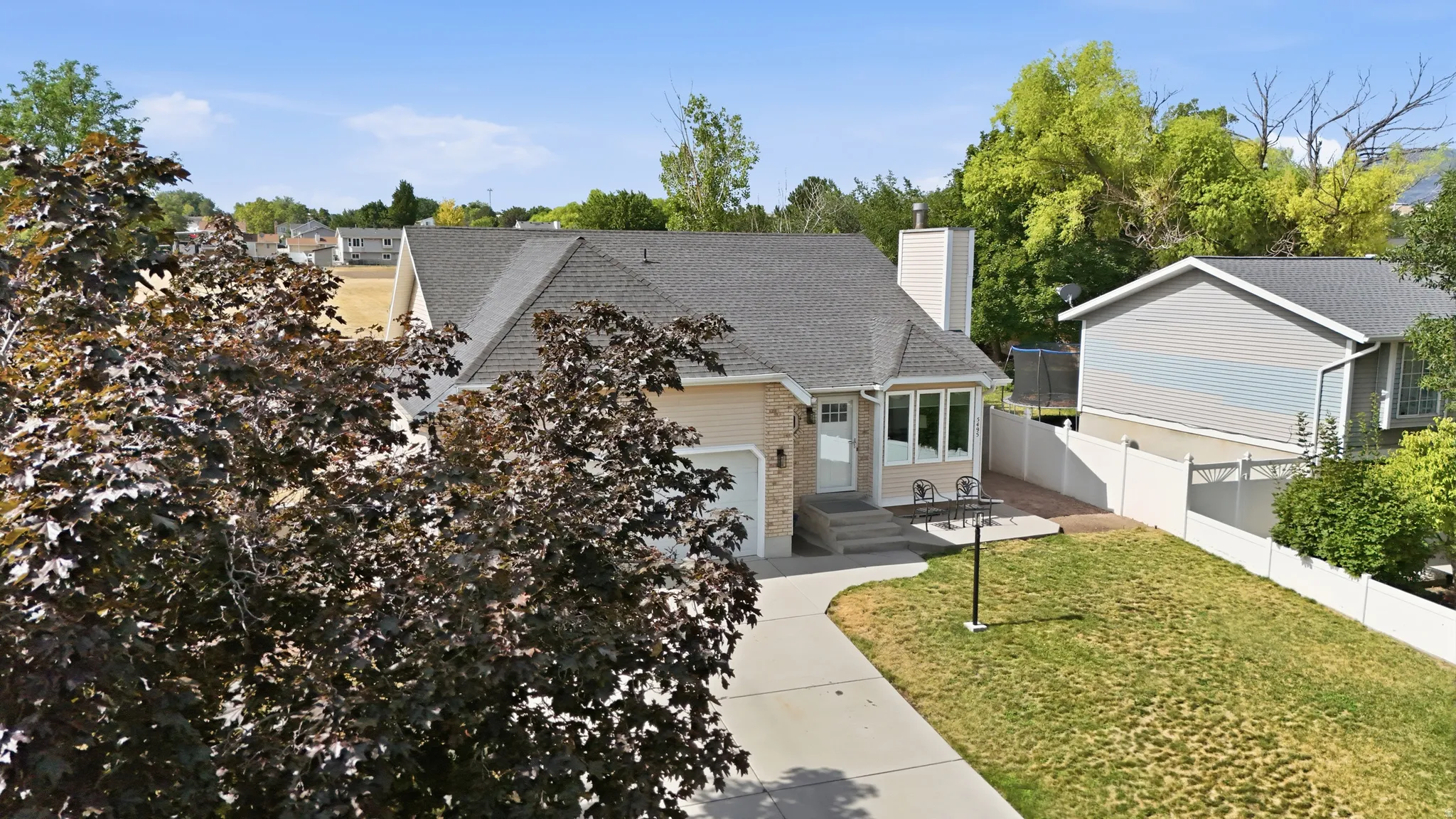 Light-colored exterior siding with brick accents, gray shingle roof, and a front-facing attached garage
