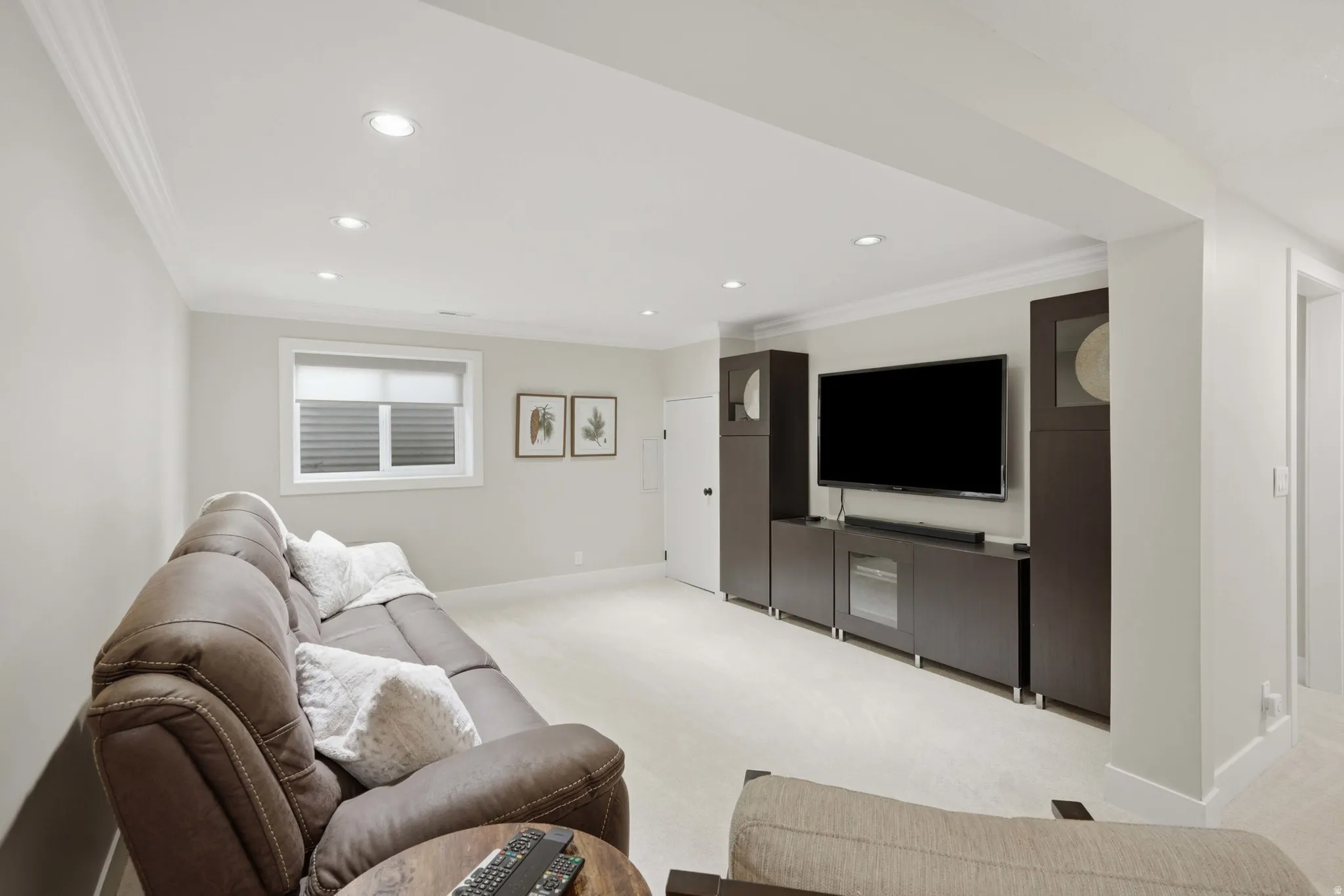 Recessed lighting illuminates this room featuring light-colored carpet flooring