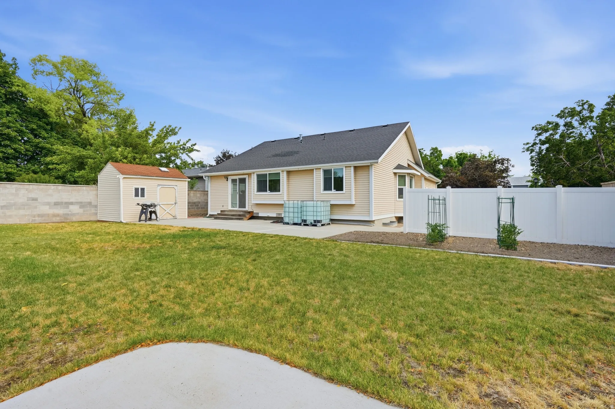 Spacious backyard with a lawn area and concrete patio