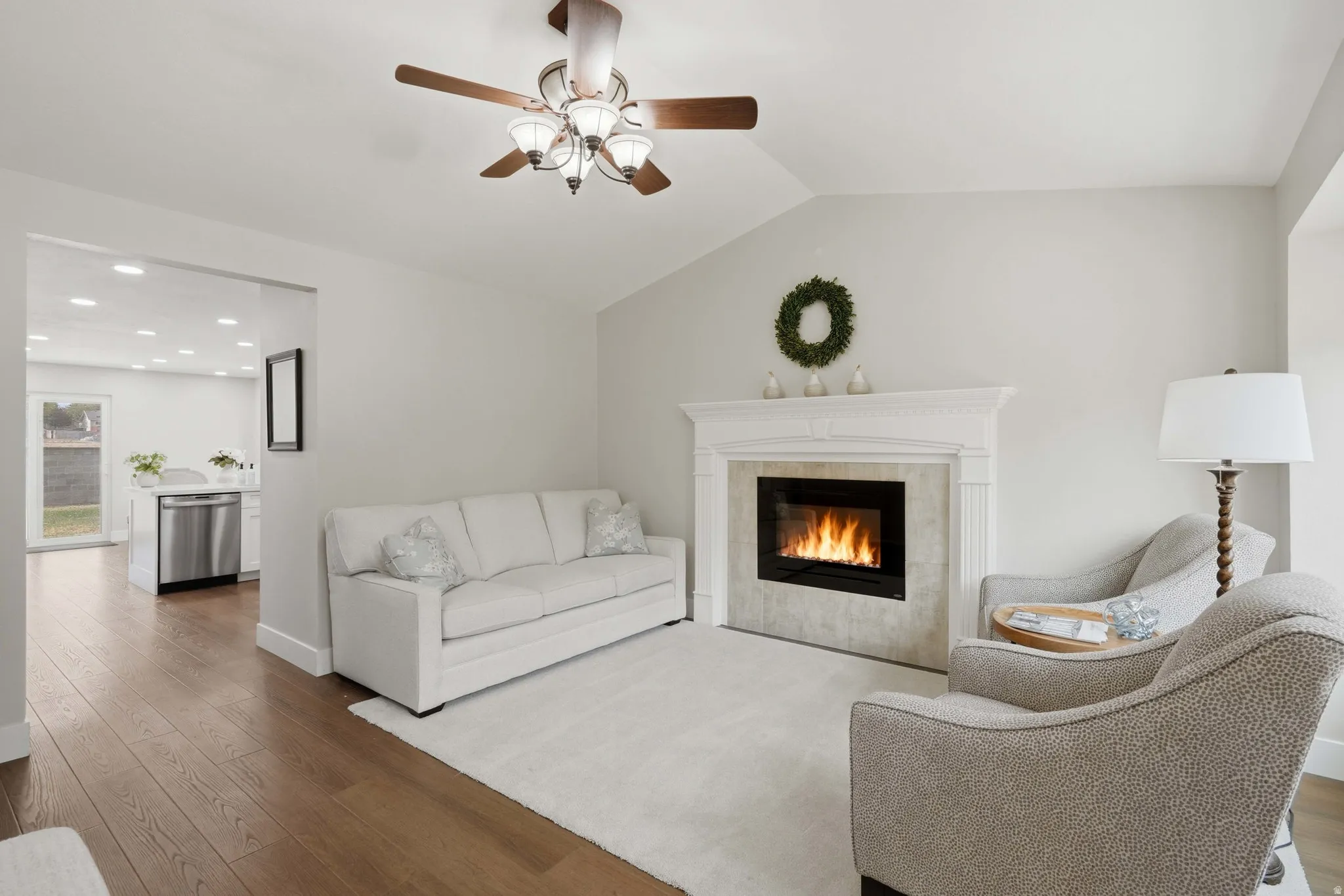 Living area featuring a vaulted ceiling and wood-finish flooring