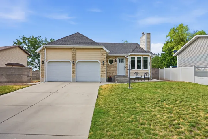 Light brick and siding exterior featuring a two-car garage, a bay window, and a concrete driveway