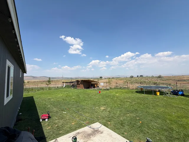 Expansive green lawn with a concrete patio
