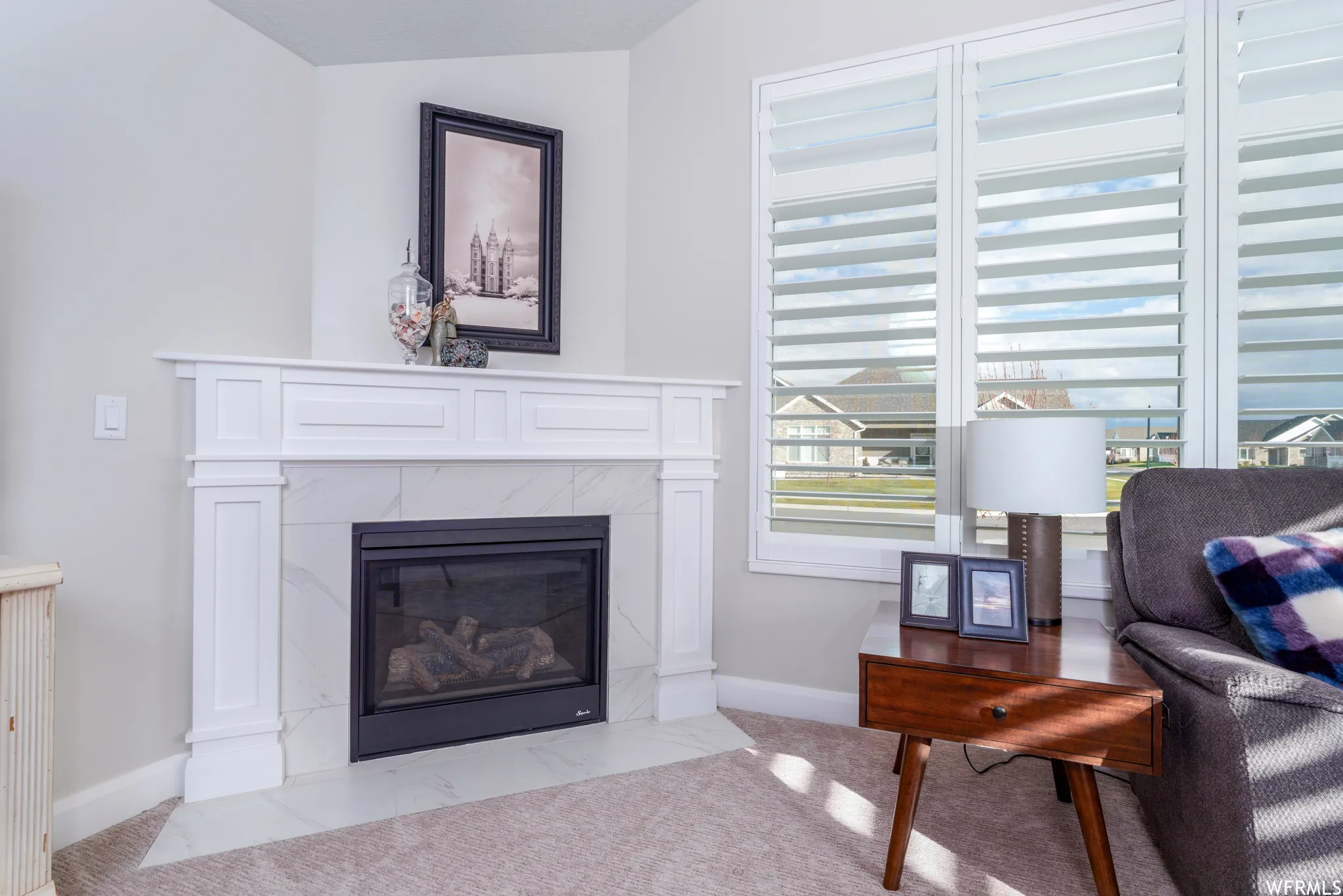 Built-in fireplace with a white mantel and surround, set against light-toned walls