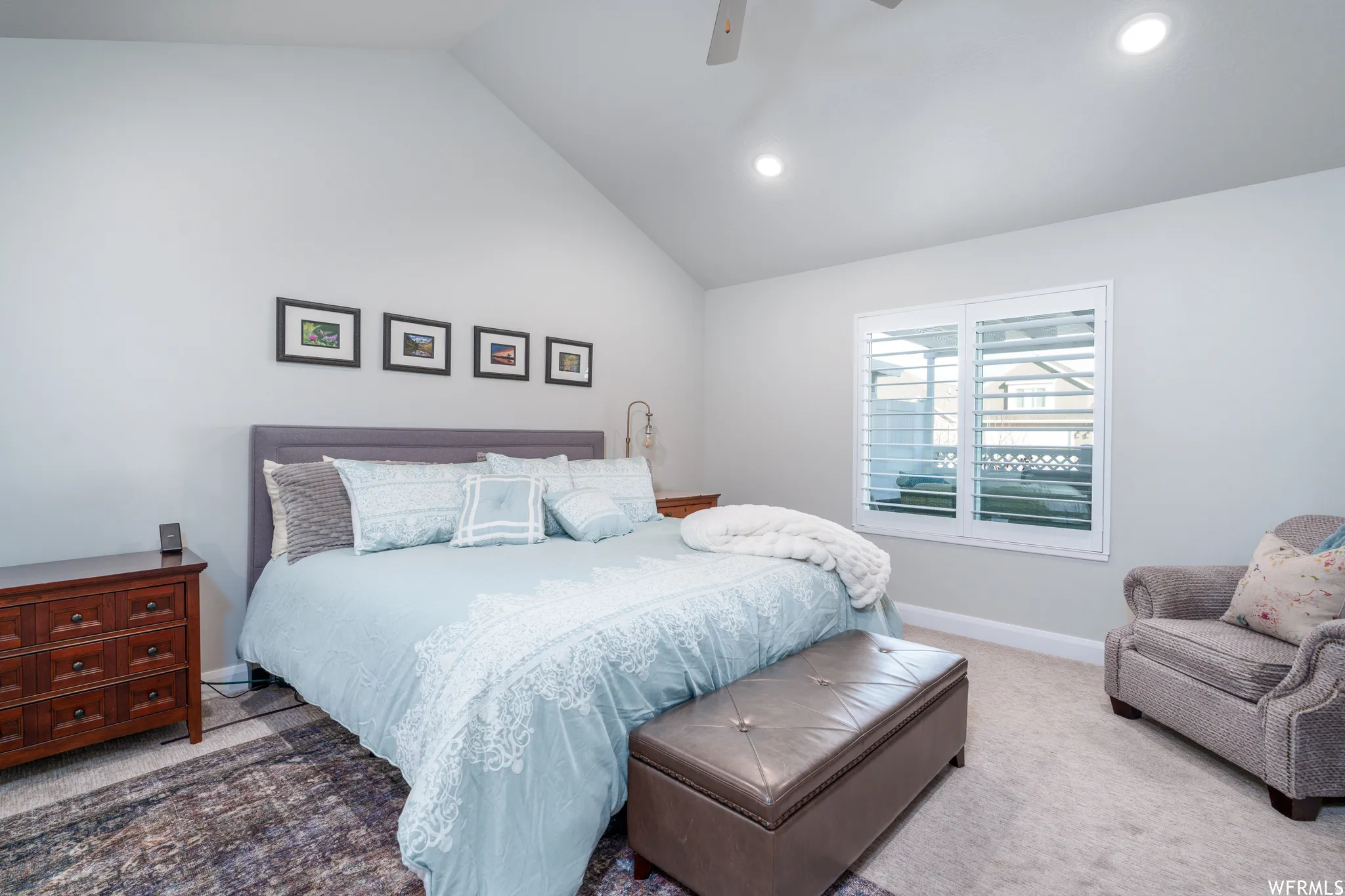 Vaulted ceiling bedroom featuring plush carpeting, plantation shutters, and recessed lighting