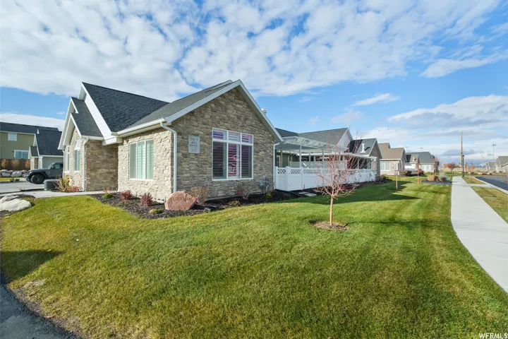 Stone veneer facade with white trim and dark shingle roofing