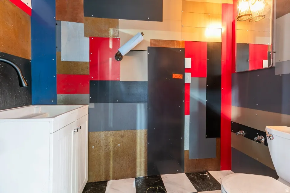 Bathroom featuring a checkerboard floor and a white vanity with an integrated sink