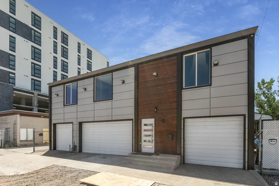 Modern facade featuring wood-look paneling and light gray siding