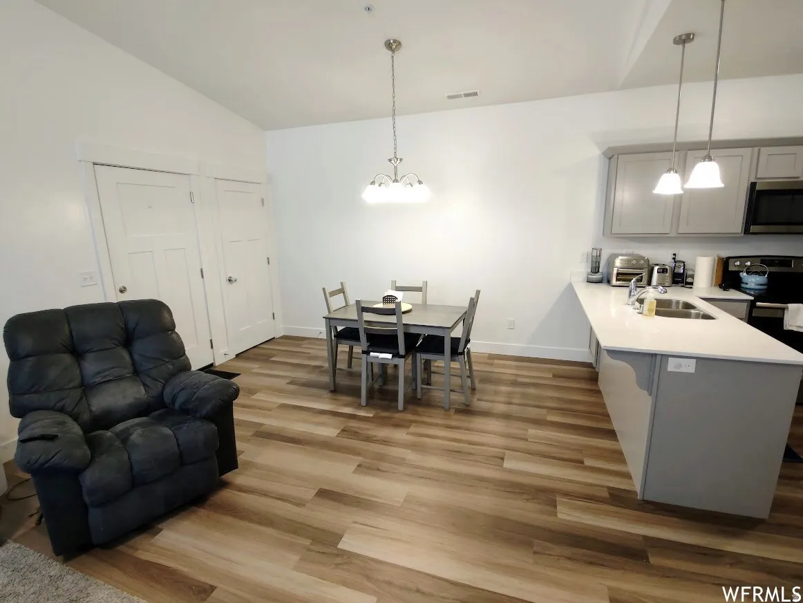 Open-concept living space featuring wood-finish flooring, white walls, and a recessed ceiling