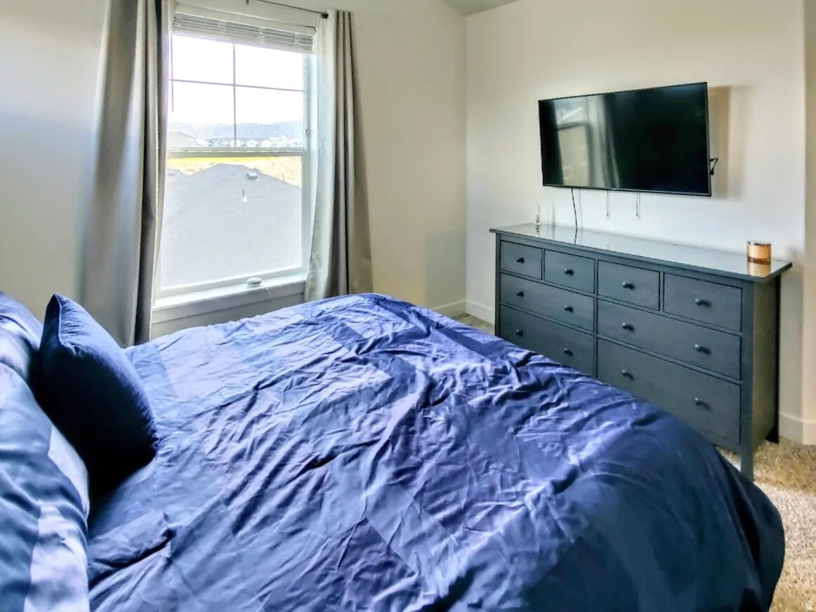Neutral wall tones complement plush carpeting in this bedroom space