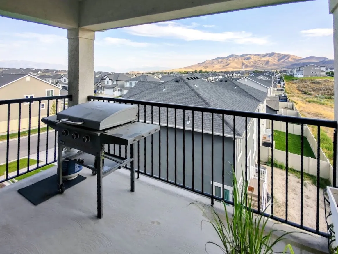 Upper-level balcony featuring concrete flooring, black metal railings, and structural columns