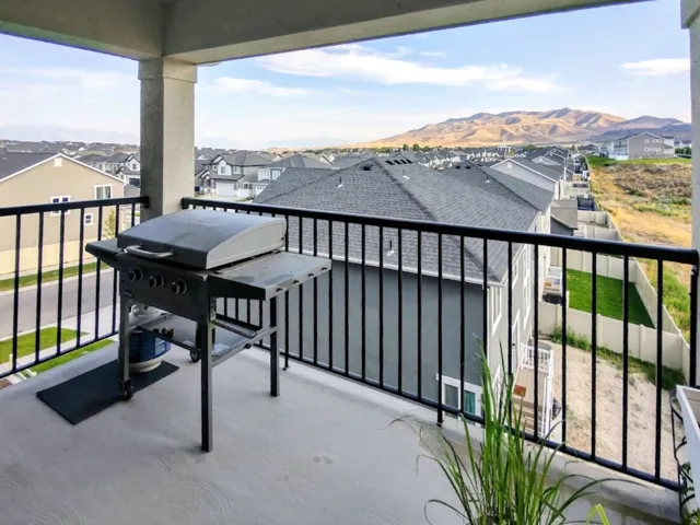 Upper-level balcony featuring concrete flooring, black metal railings, and structural columns