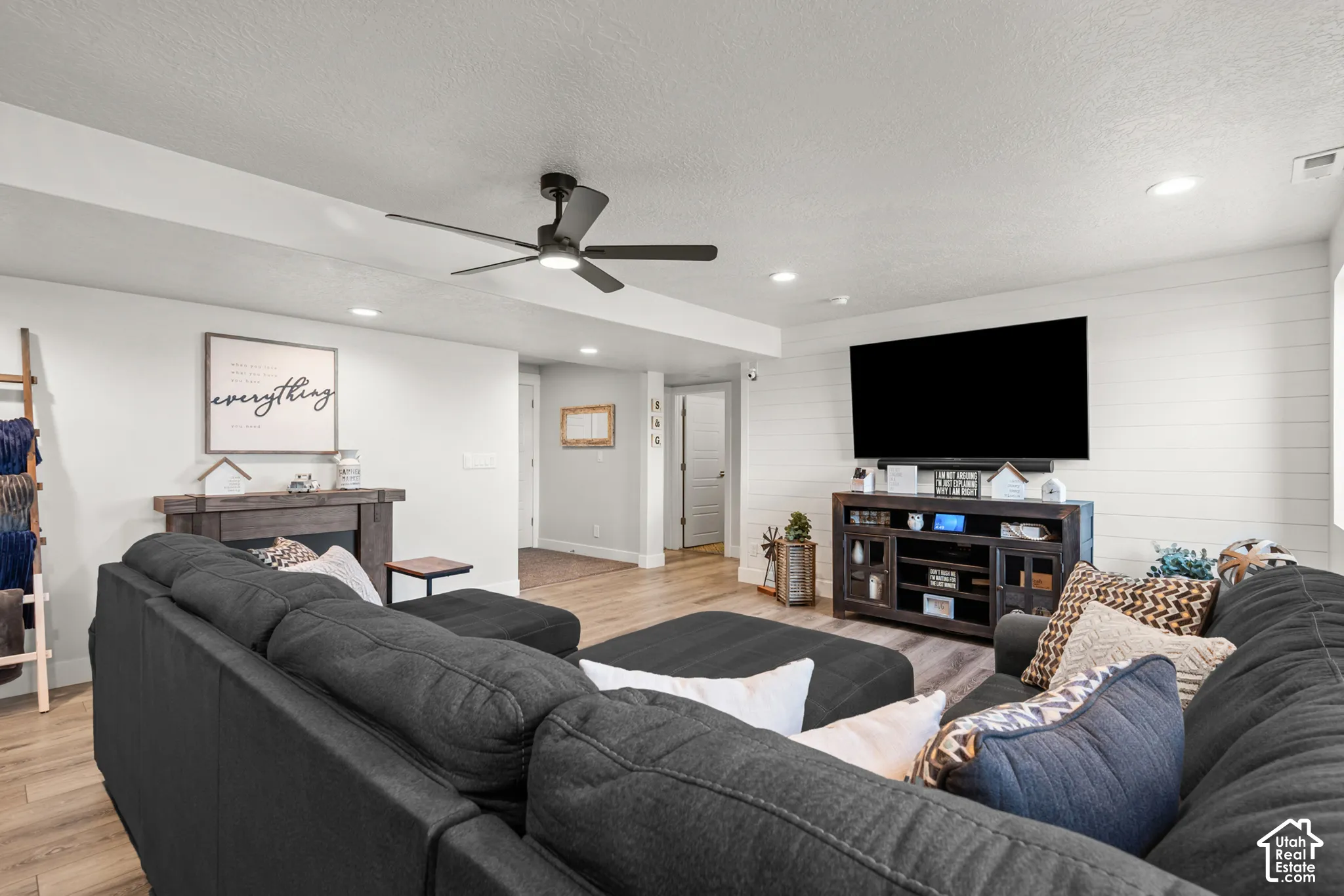 Open living area featuring wood-finish flooring, recessed lighting, and a modern ceiling fan