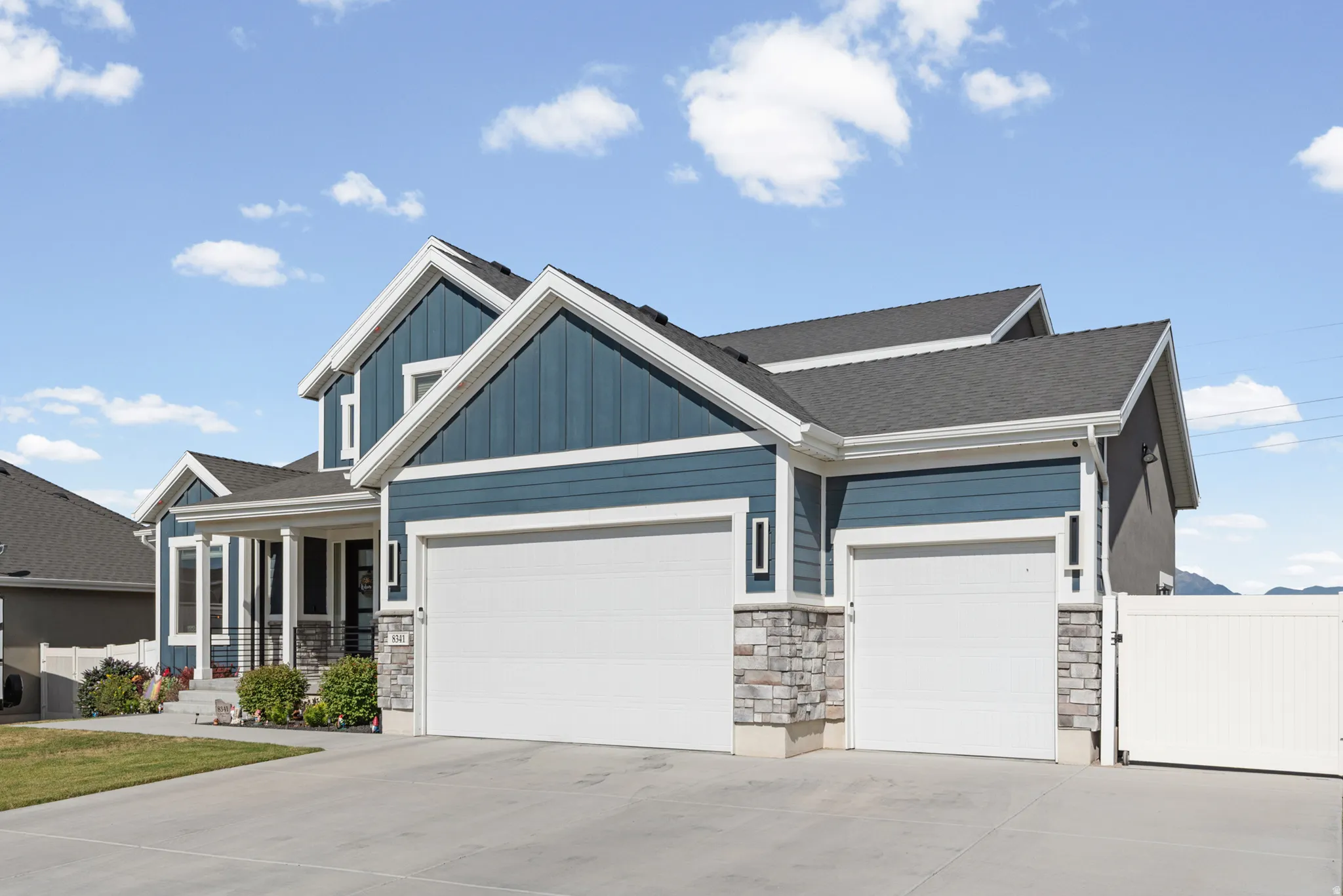 Contemporary two-story residence featuring blue siding and stone accents