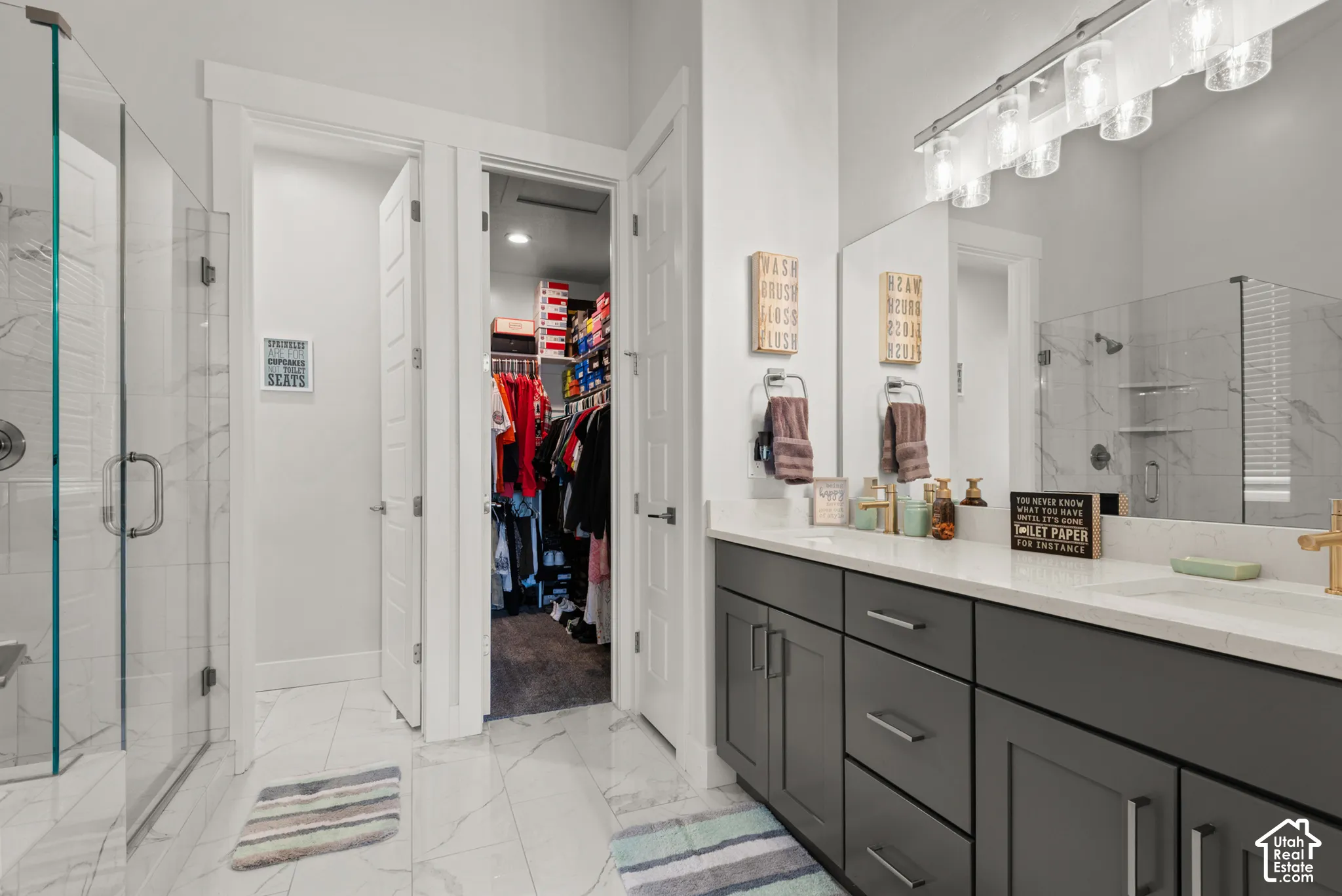 Modern bathroom featuring a dual vanity with dark cabinetry and light countertops