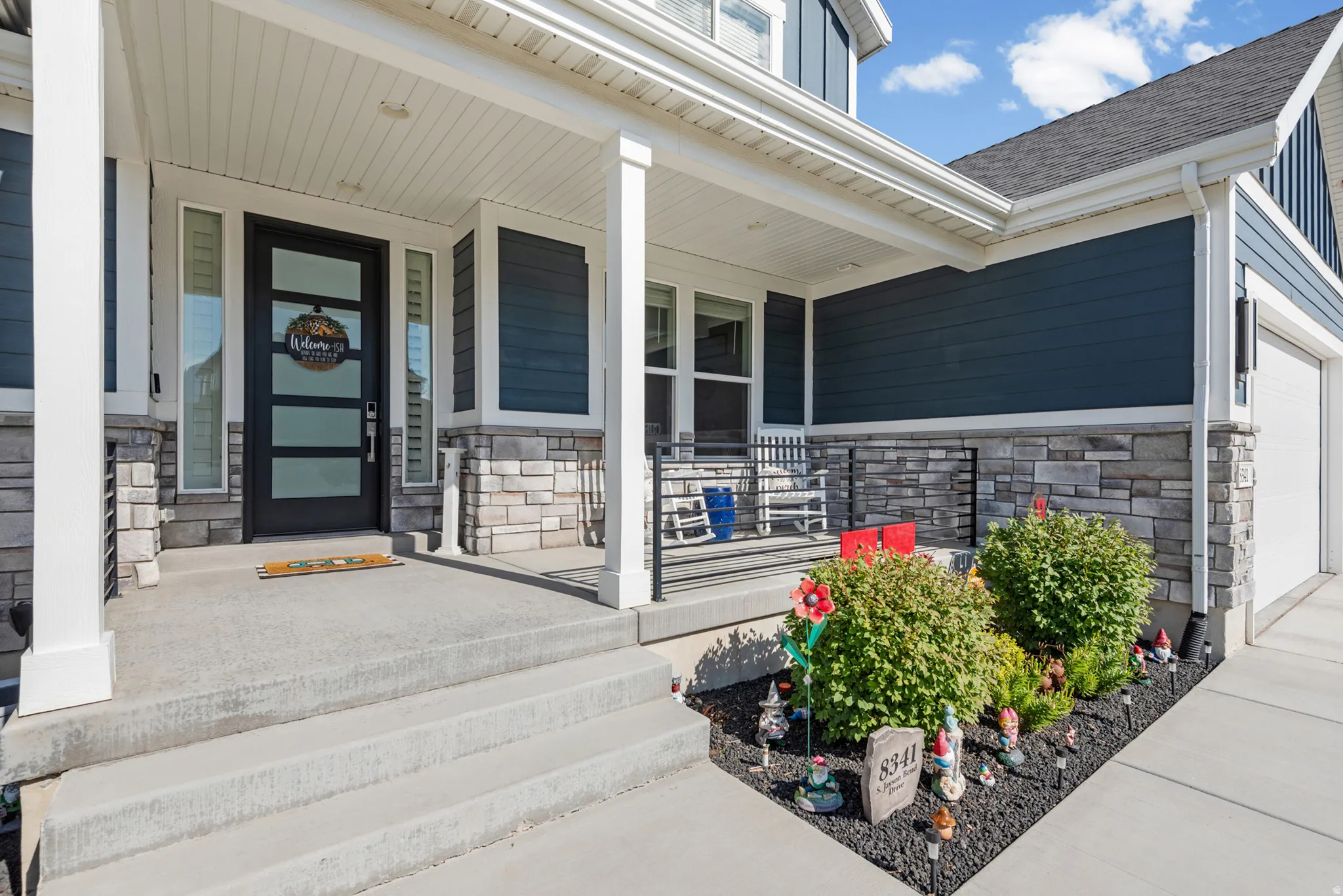 Covered concrete porch and steps with decorative stone veneer accents