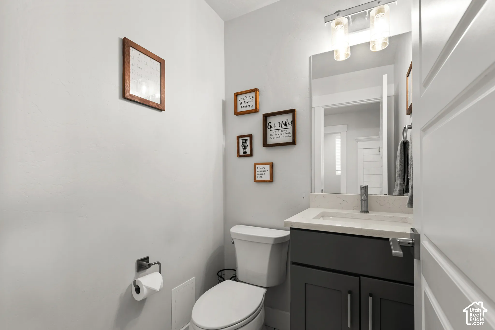 Powder room featuring a modern dark gray vanity with a light countertop and an integrated white rectangular sink