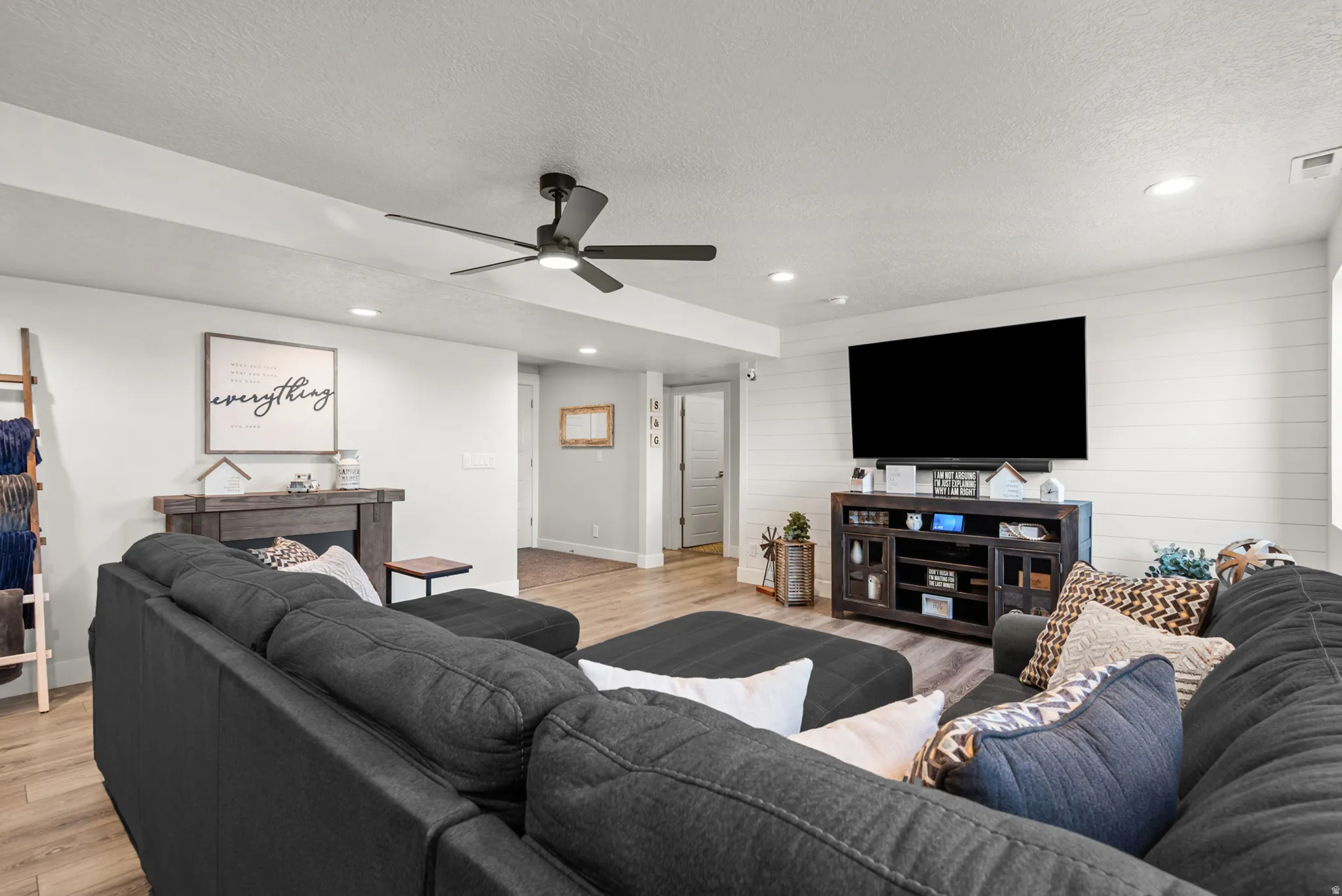 Open living area featuring wood-finish flooring, recessed lighting, and a modern ceiling fan