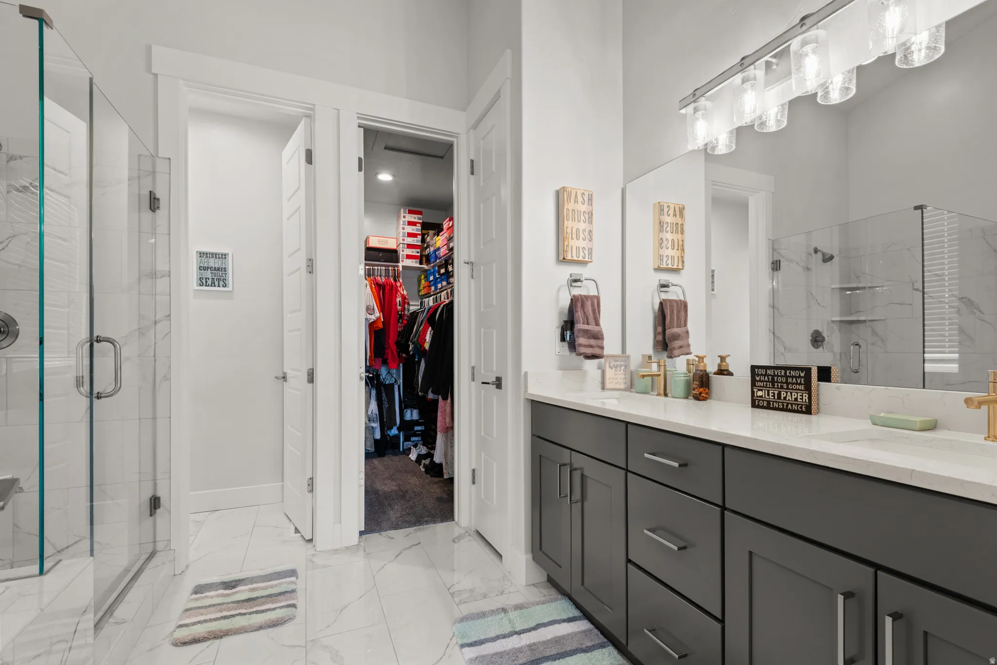 Modern bathroom featuring a dual vanity with dark cabinetry and light countertops
