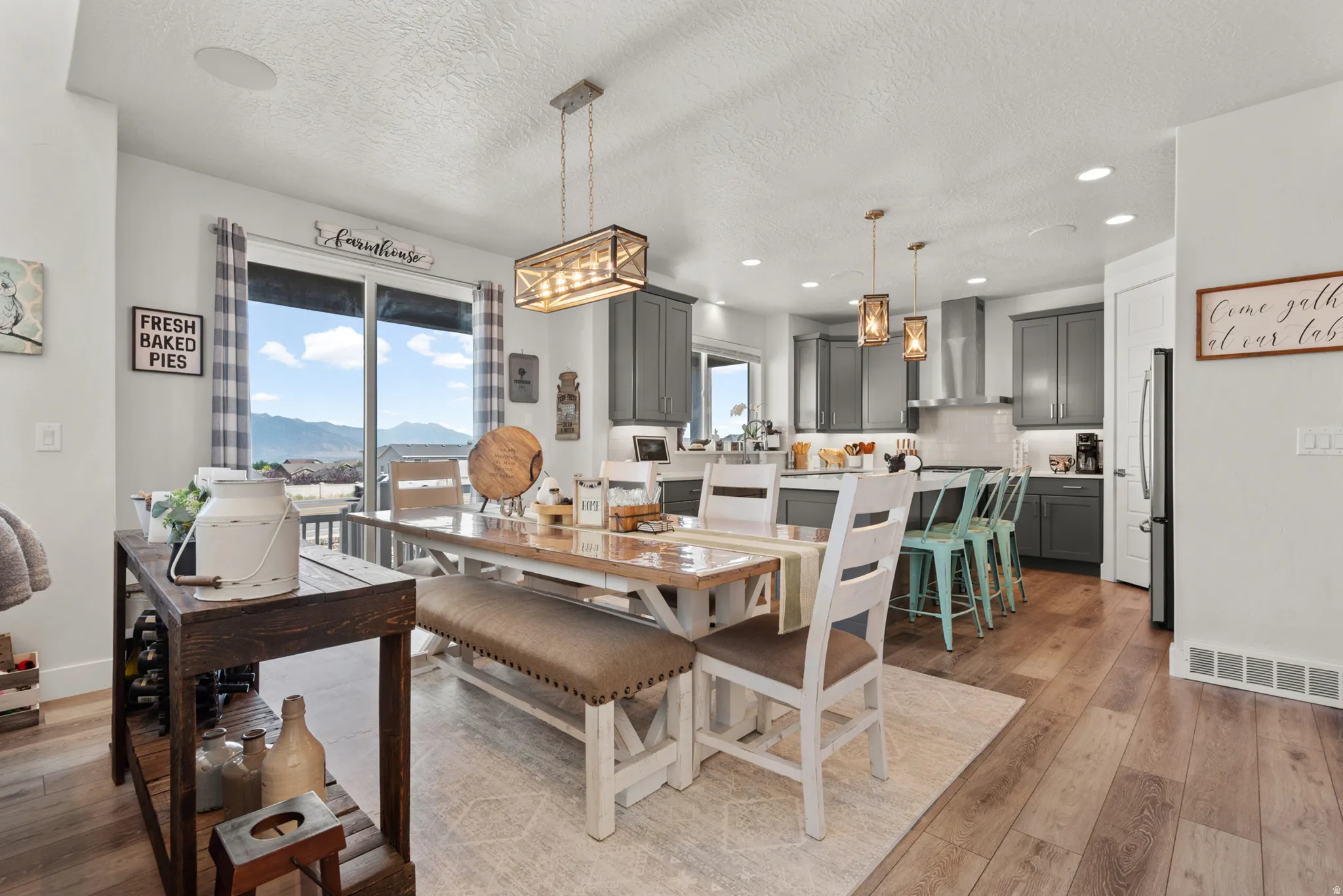 Open-concept living area featuring wood-finish flooring, a contemporary dining chandelier, and recessed lighting