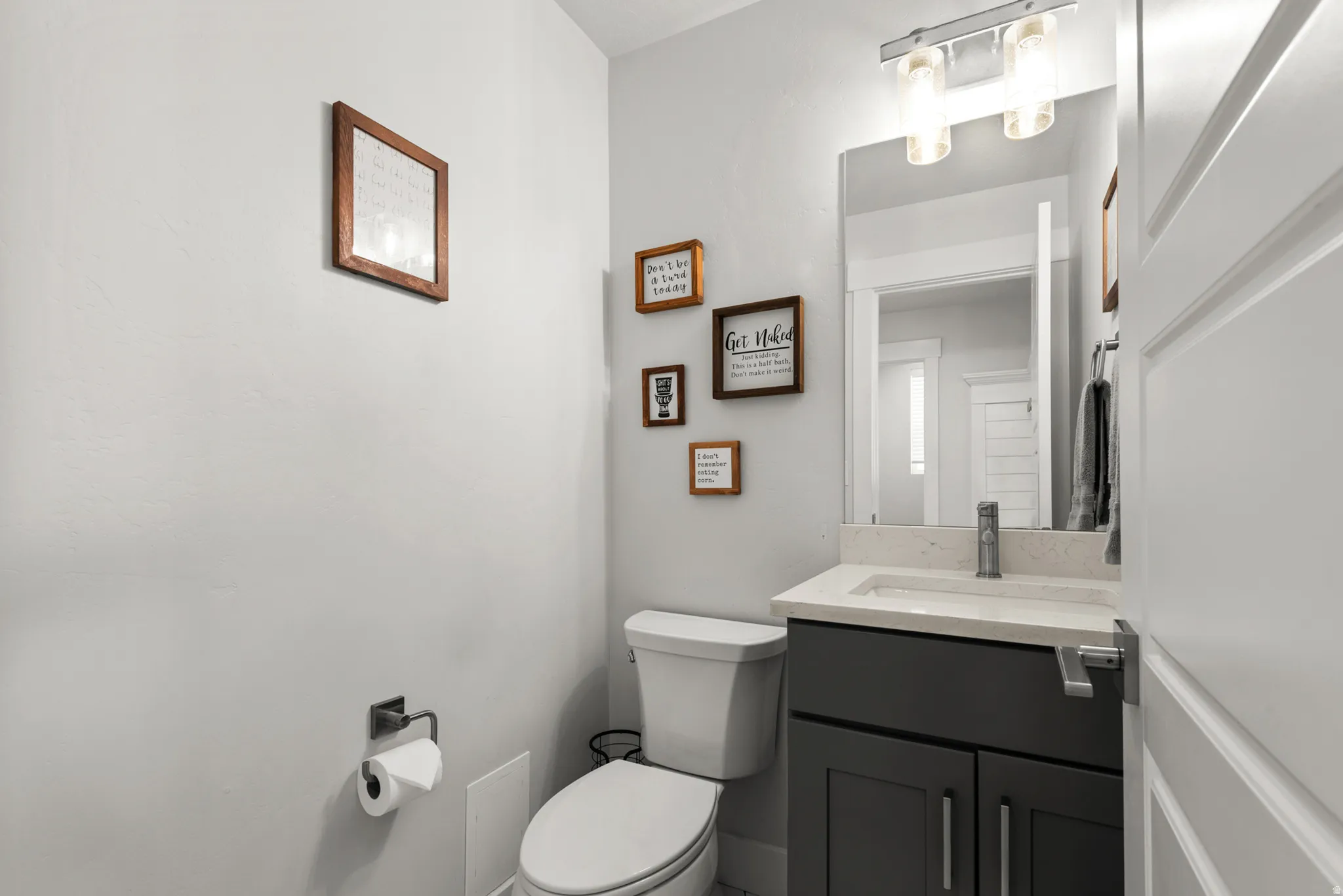 Powder room featuring a modern dark gray vanity with a light countertop and an integrated white rectangular sink