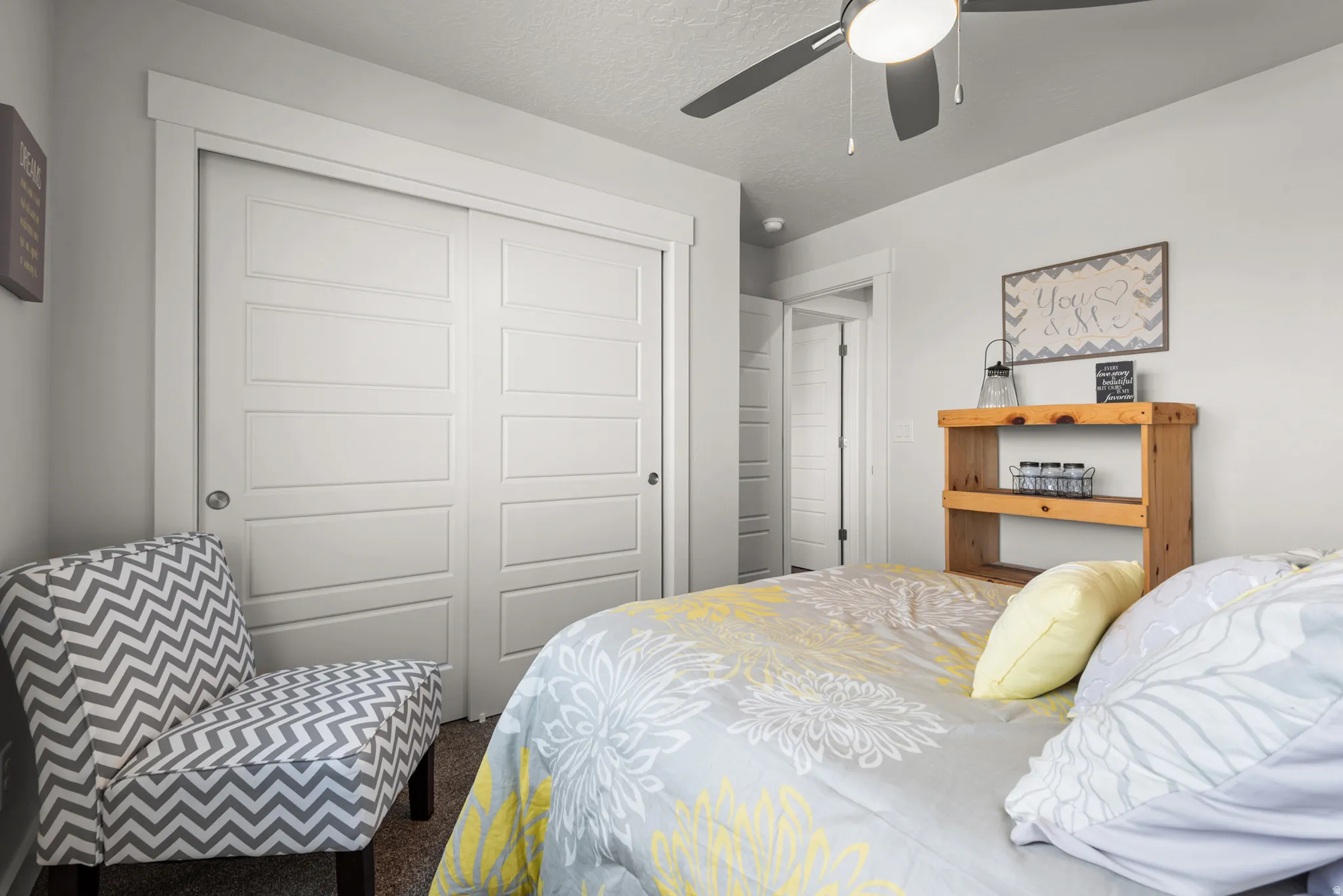 Room featuring white panel closet doors, light gray wall paint, and a ceiling fan with integrated lighting