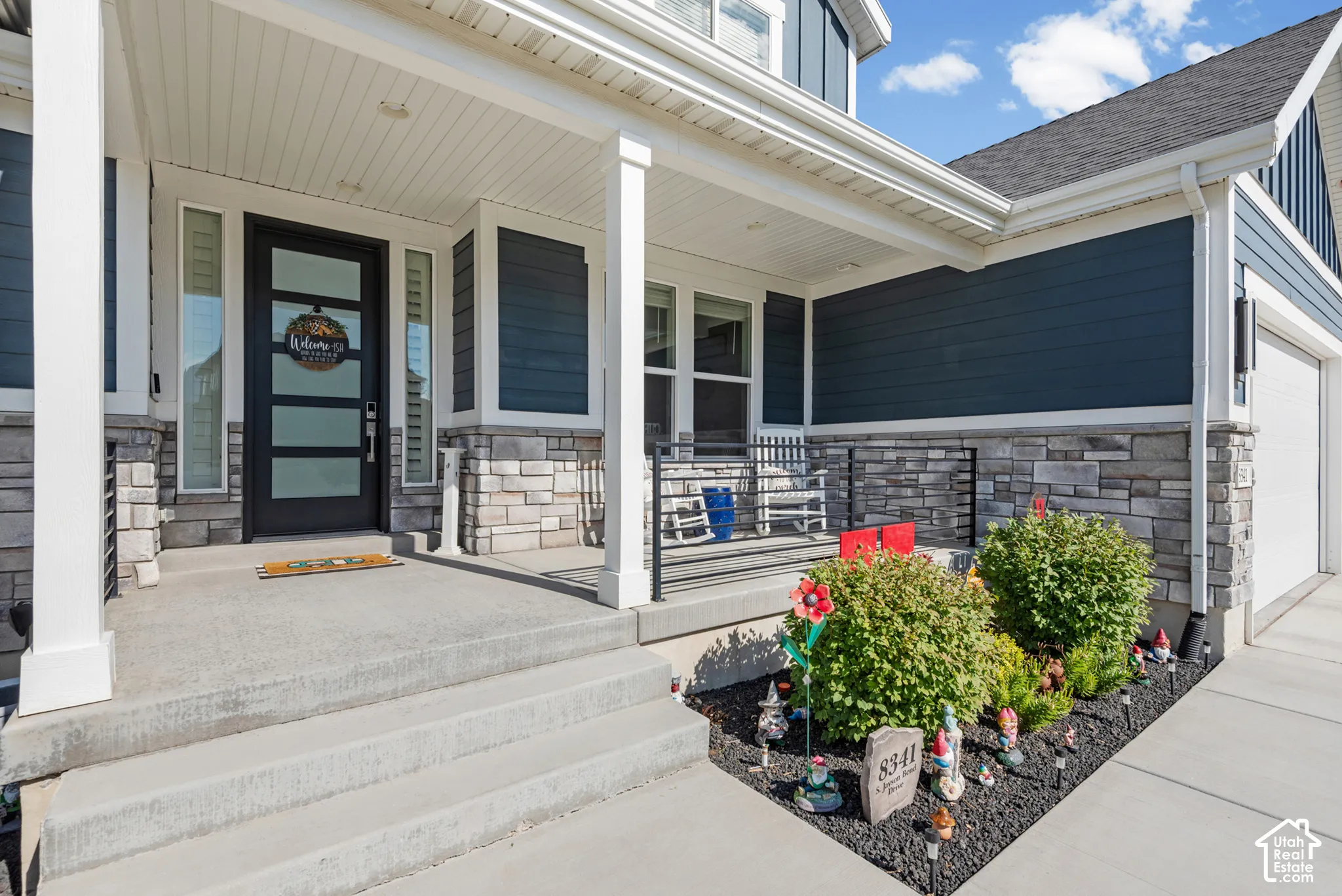 Covered concrete porch and steps with decorative stone veneer accents