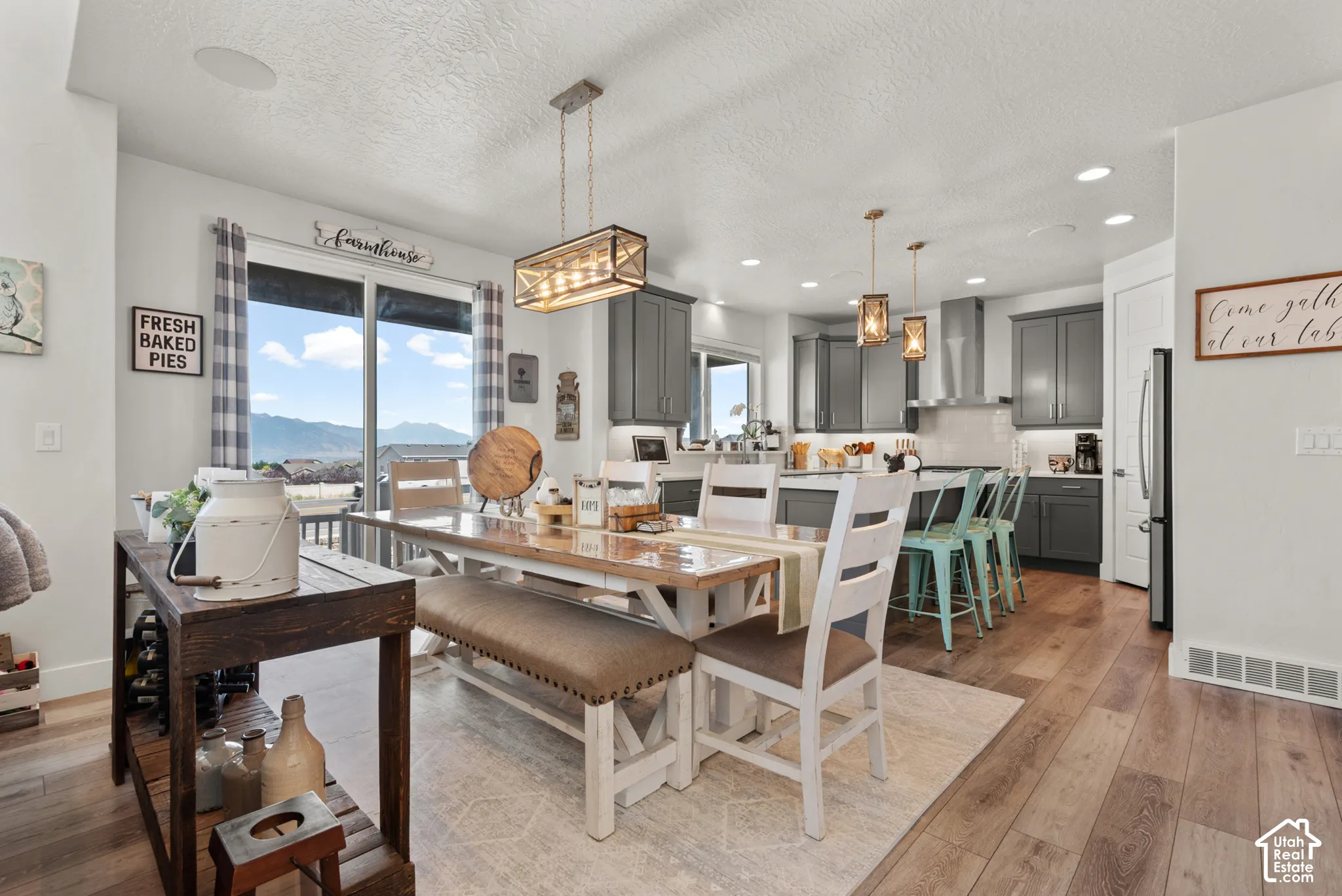 Open-concept living area featuring wood-finish flooring, a contemporary dining chandelier, and recessed lighting