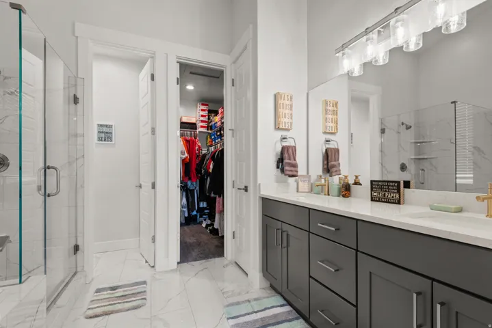 Modern bathroom featuring a dual vanity with dark cabinetry and light countertops