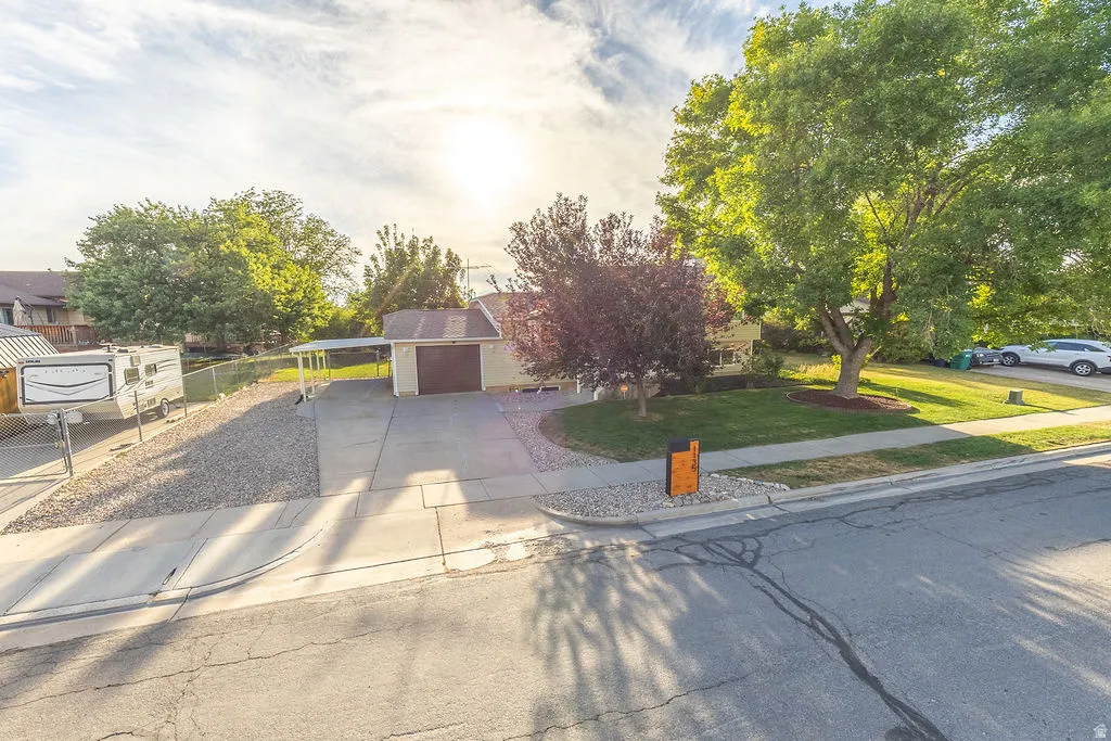 Property exterior featuring a concrete driveway, attached garage, and a covered carport