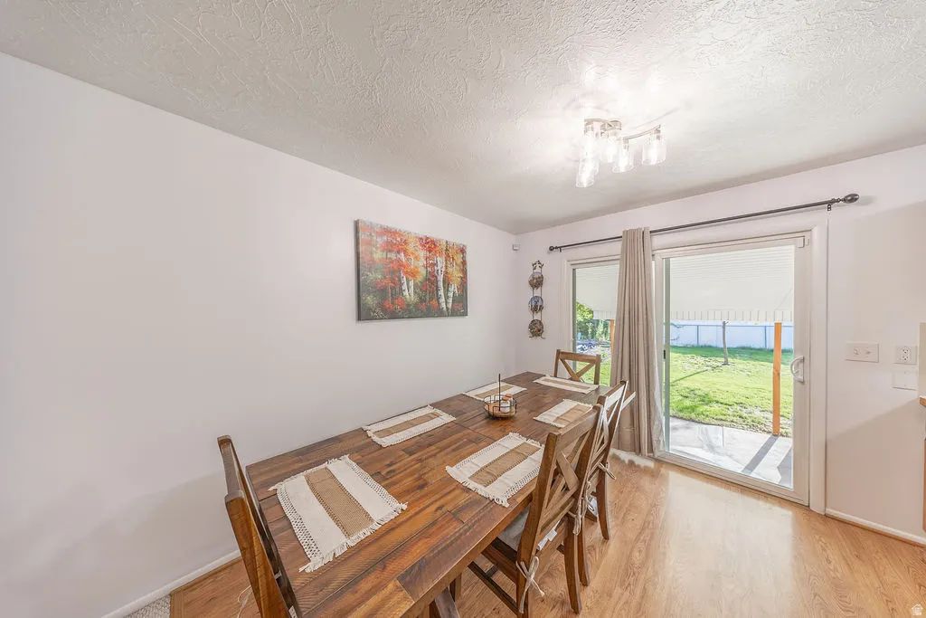 Dining area with wood-finish flooring and a contemporary overhead light fixture