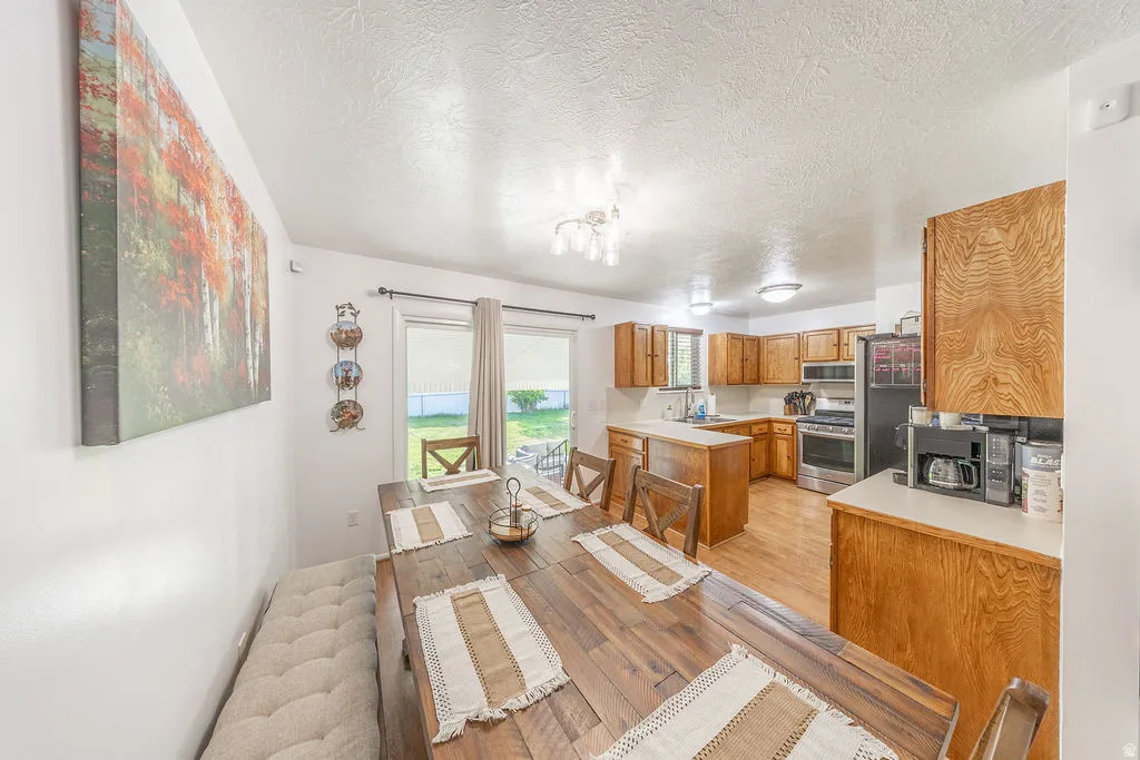 Open-concept kitchen and dining area featuring warm wood-finish flooring