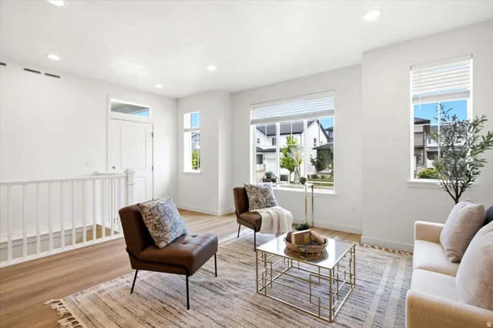 Bright living area with recessed lighting and wood-finish flooring