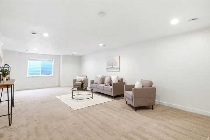 Spacious living area featuring neutral carpeting and white wall finishes