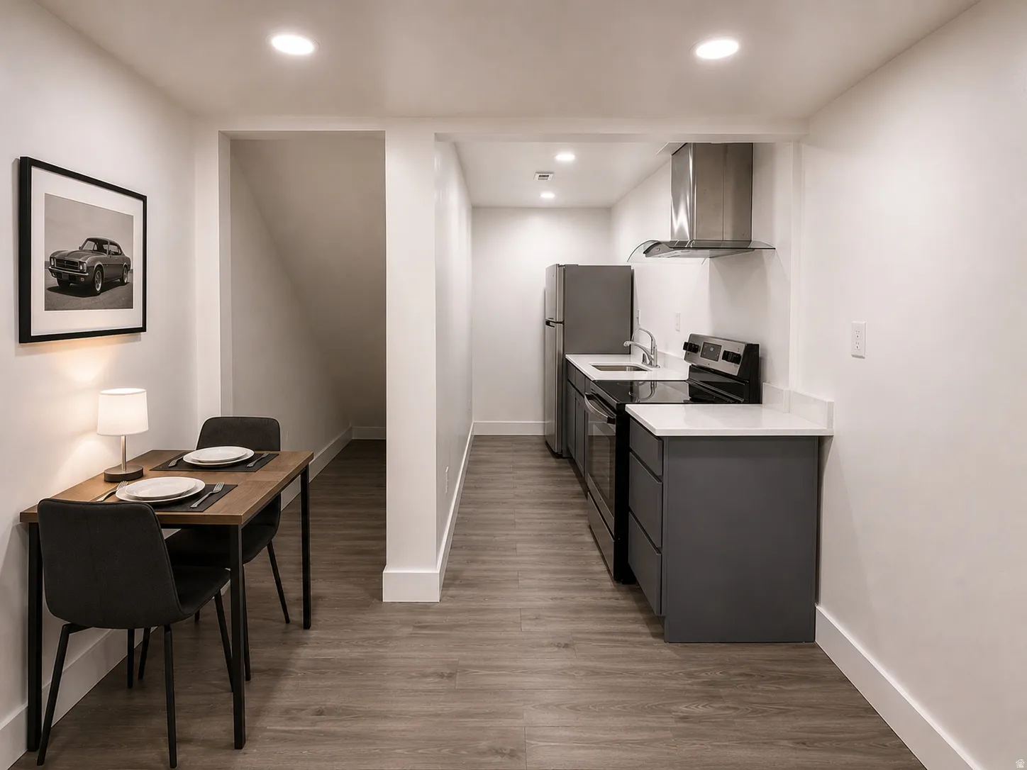 Compact kitchen featuring dark gray cabinetry, white countertops, and stainless steel appliances