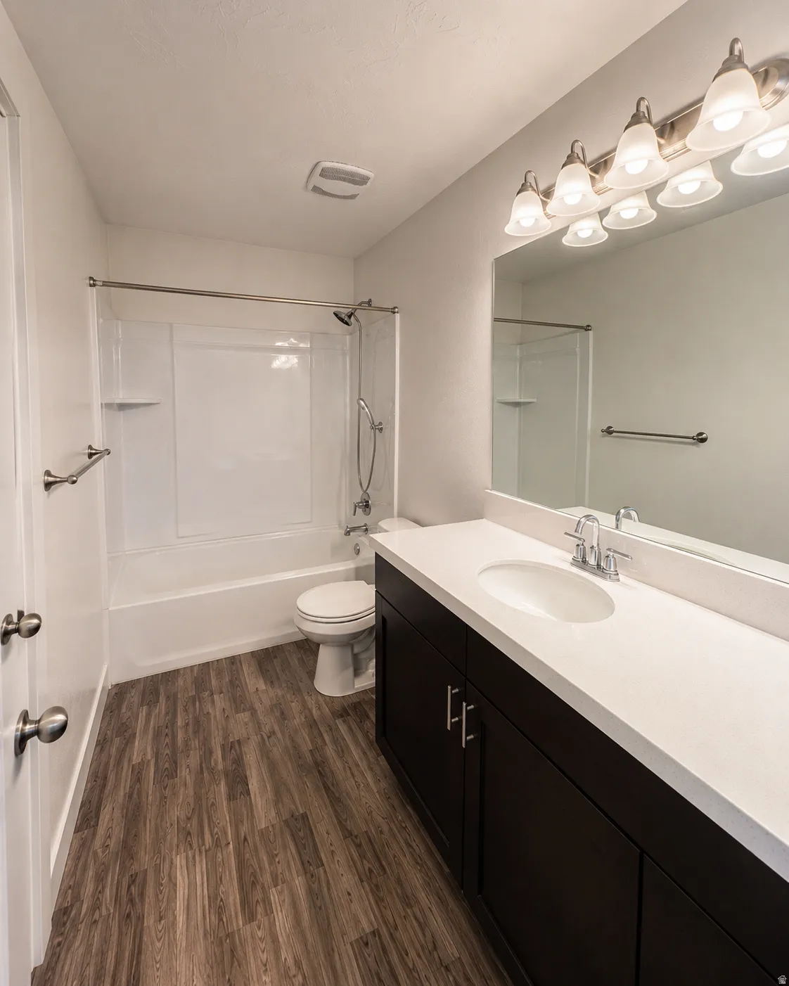 Bathroom vanity with a white countertop and dark wood-finish cabinetry