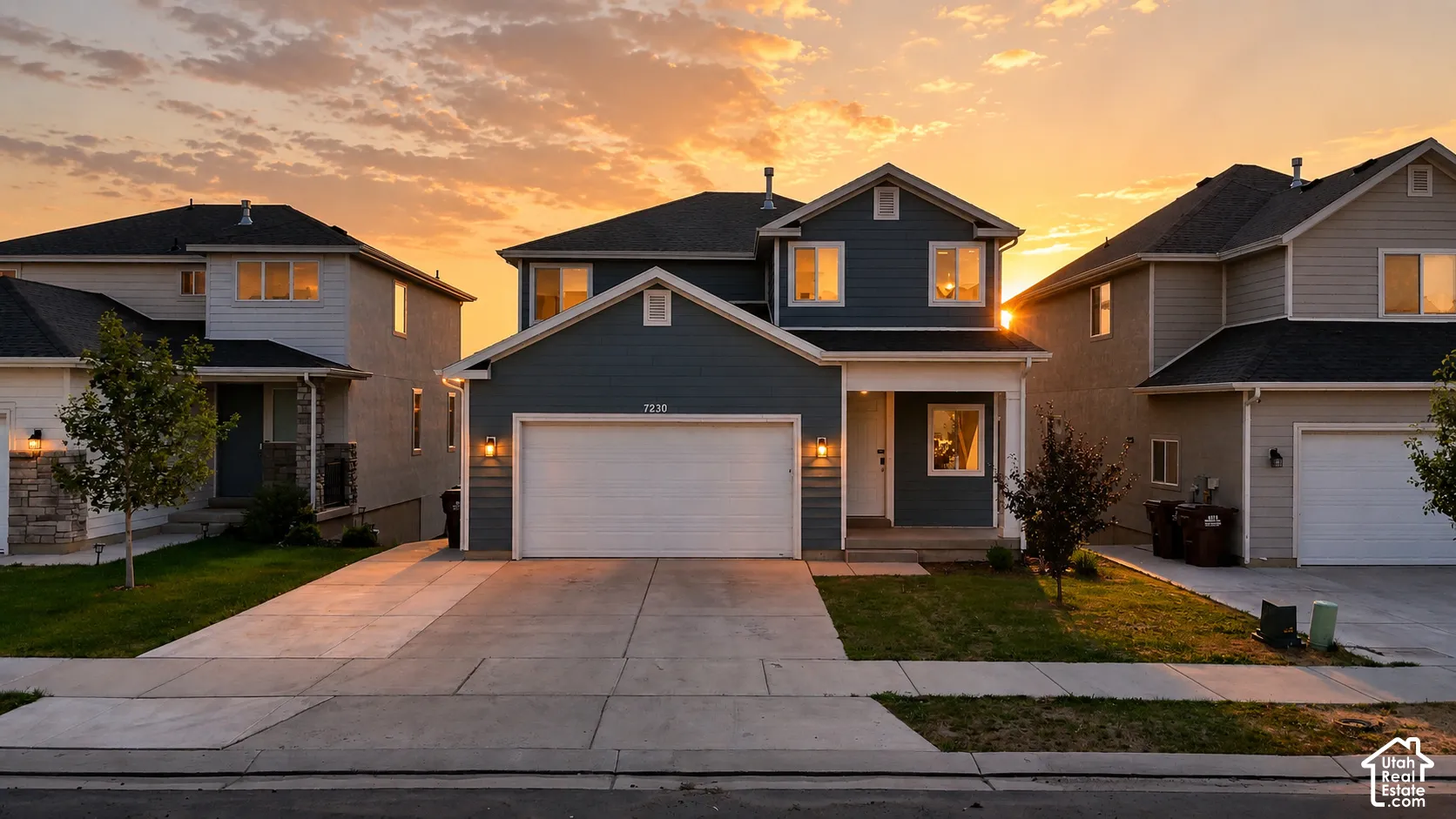Two-story residence featuring a blue siding exterior, white trim, and a prominent two-car garage