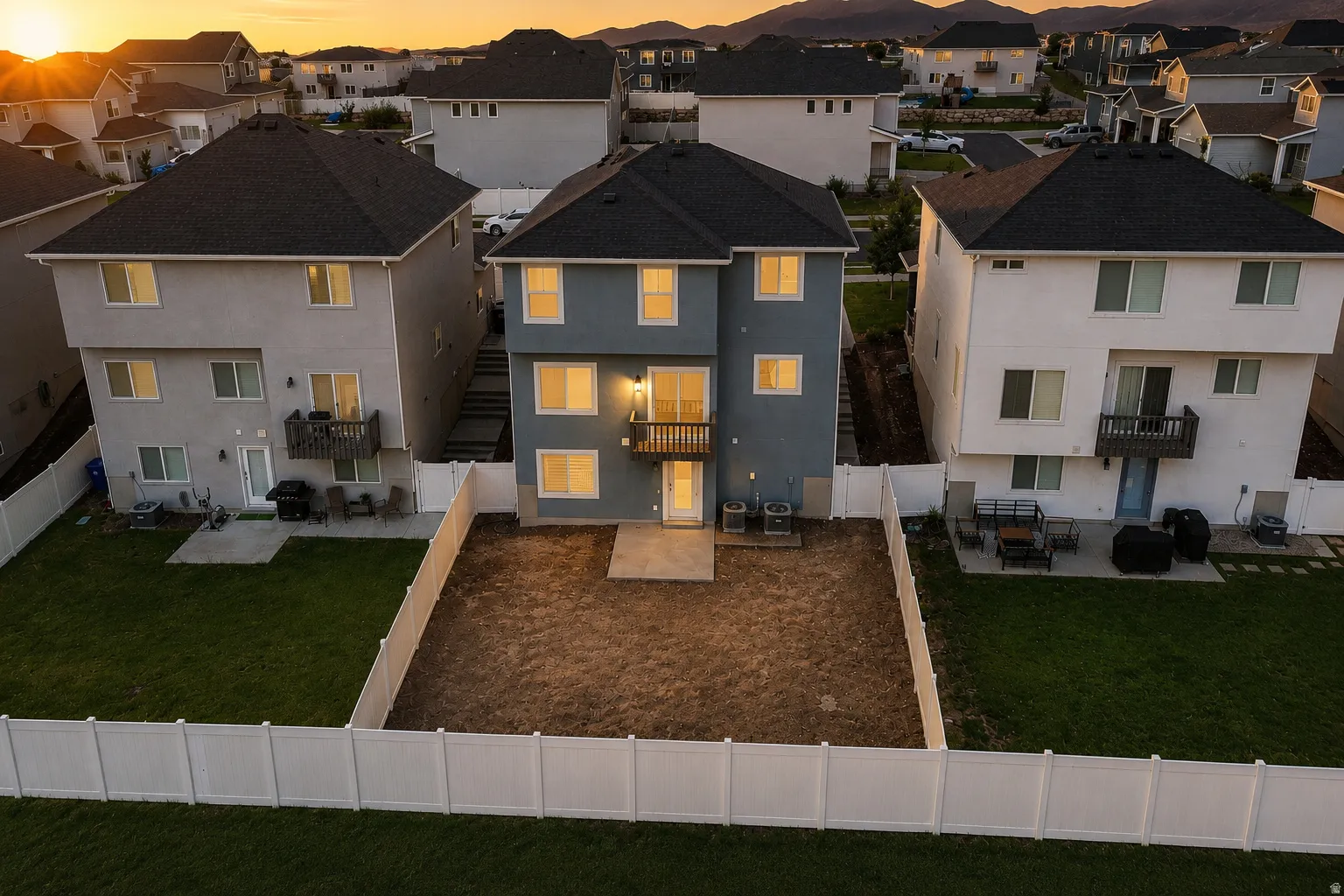 Newly constructed residence featuring a blue exterior, black roof, and a private rear yard