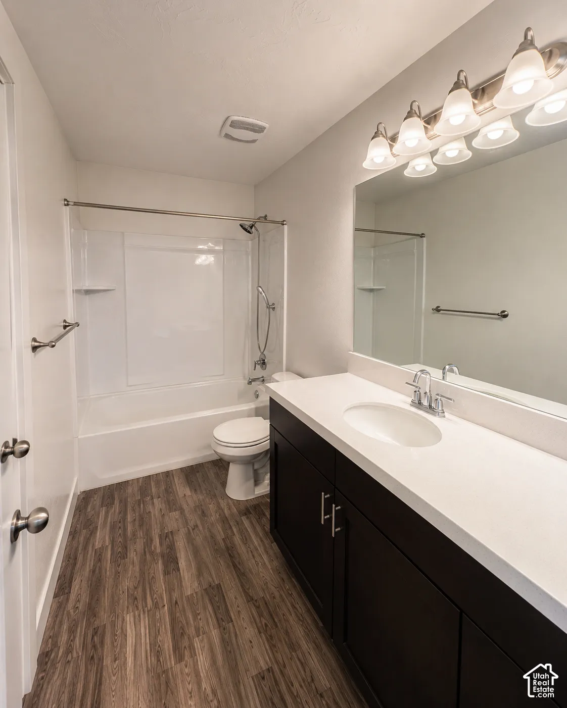 Bathroom vanity with a white countertop and dark wood-finish cabinetry