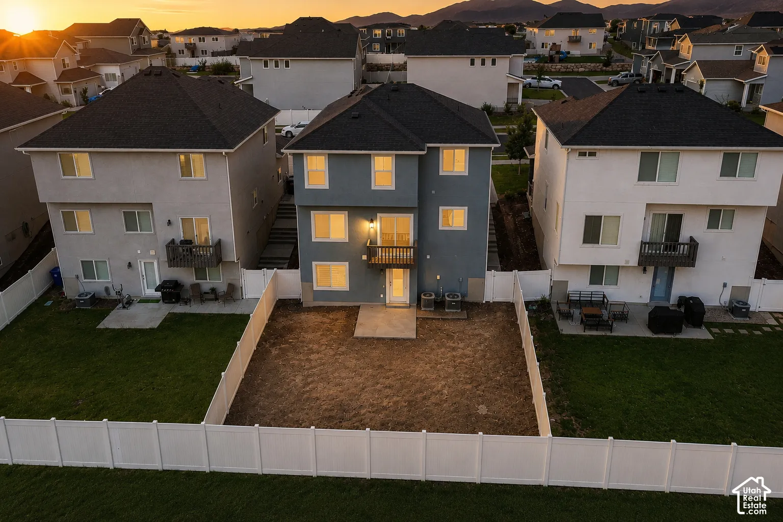 Newly constructed residence featuring a blue exterior, black roof, and a private rear yard