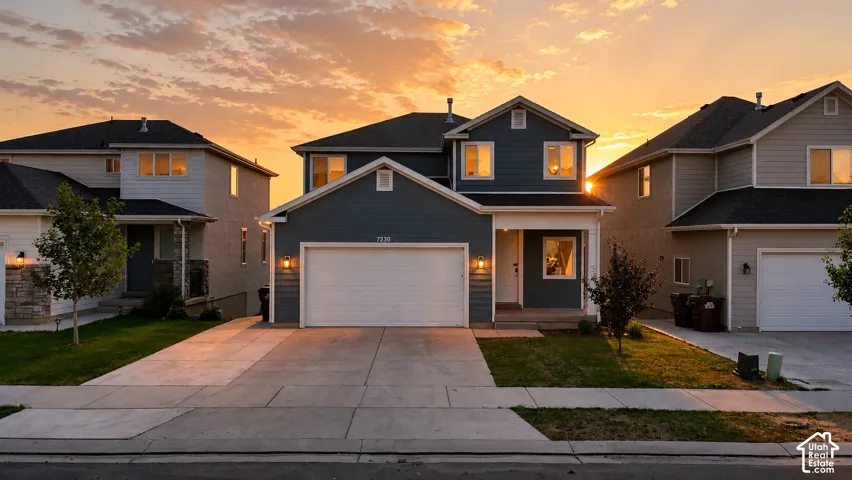 Two-story residence featuring a blue siding exterior, white trim, and a prominent two-car garage