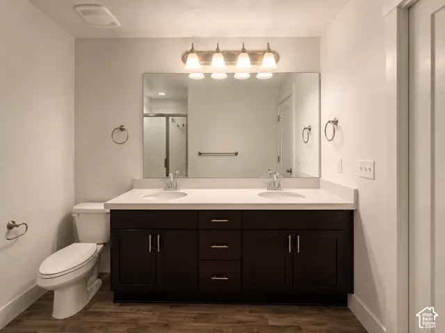 Dual vanity with white solid surface countertop, dark wood-finish cabinetry, and brushed nickel hardware