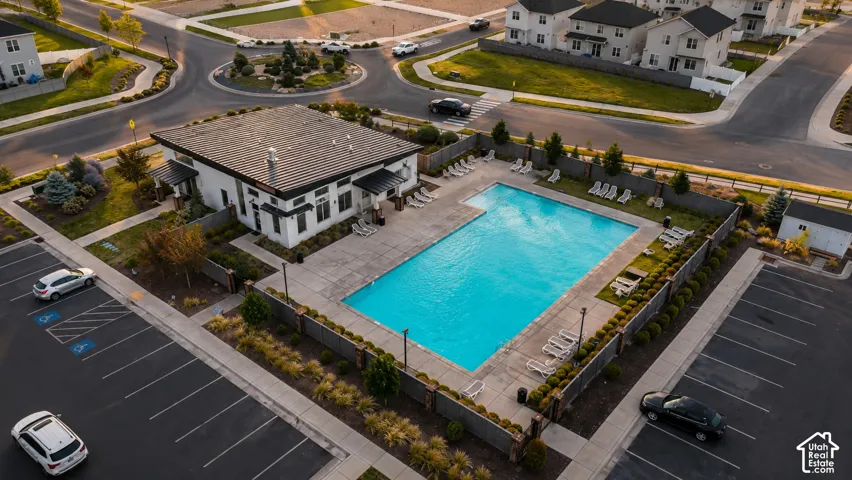 Modern building with a dark metal roof, featuring an adjacent rectangular swimming pool and surrounding paved patio