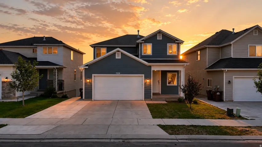 Two-story residence featuring a blue siding exterior, white trim, and a prominent two-car garage