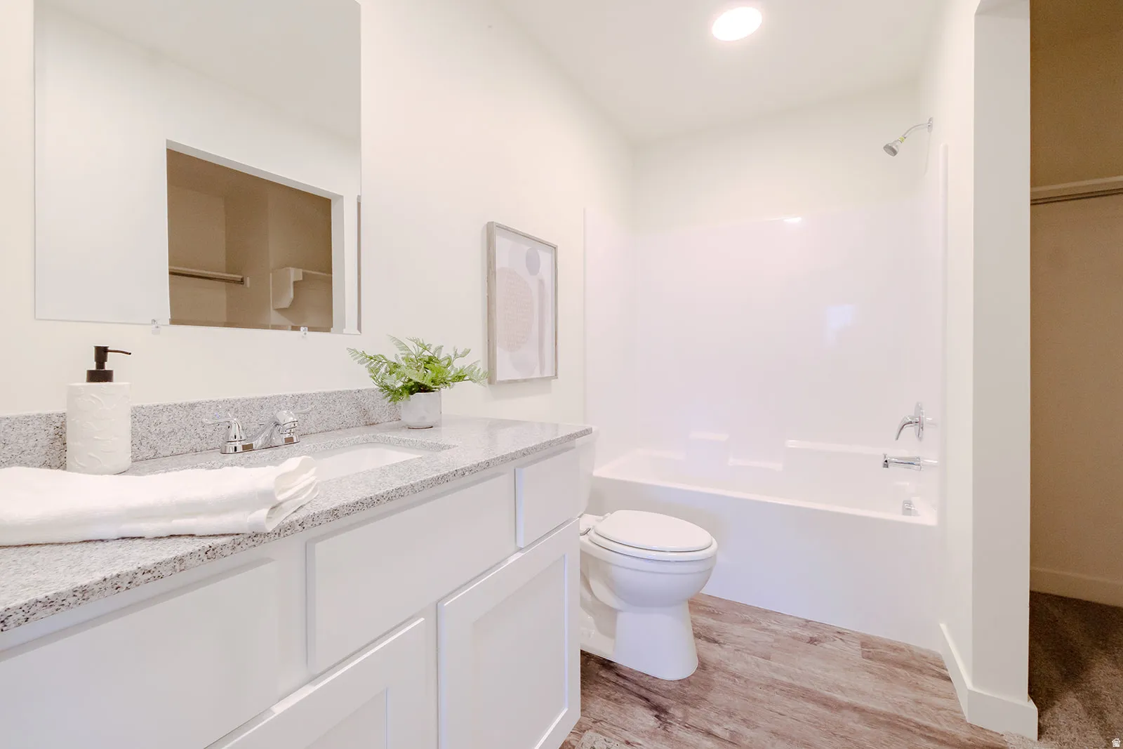 Bathroom featuring a white vanity with a light-colored countertop, an integrated sink, and a chrome faucet