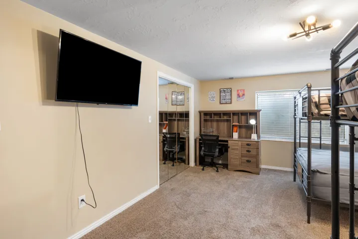 Office with light carpet and a textured ceiling