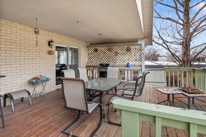 Wooden deck with outdoor dining space and grilling area