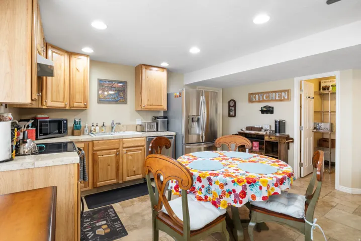 Kitchen featuring appliances with stainless steel finishes, recessed lighting, light brown cabinets, and range hood