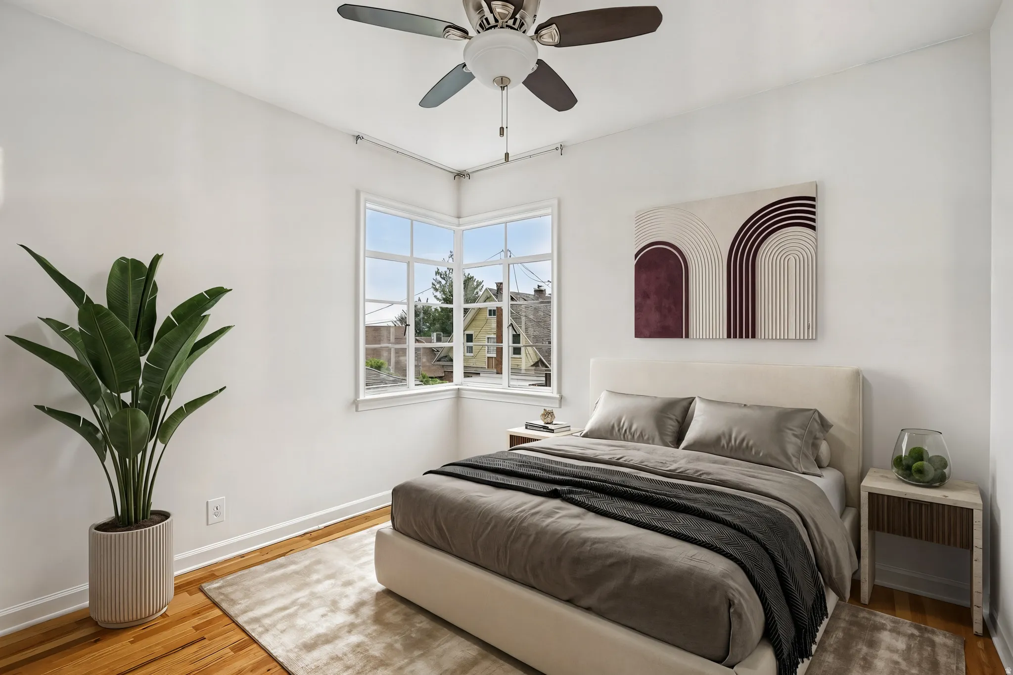 Bedroom featuring corner window, wood-finish flooring, white walls, and a ceiling fan with integrated lighting