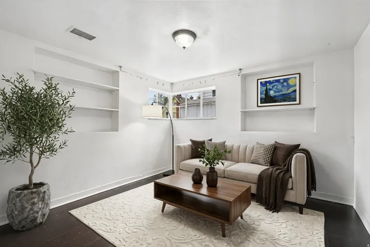 Living area featuring dark wood-finish flooring and light-toned walls